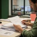 Periodista consultando documentos en una redacción de noticias andaluza